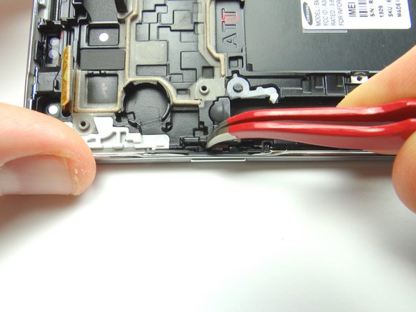 Use curved tip tweezers to press the button firmly into place.