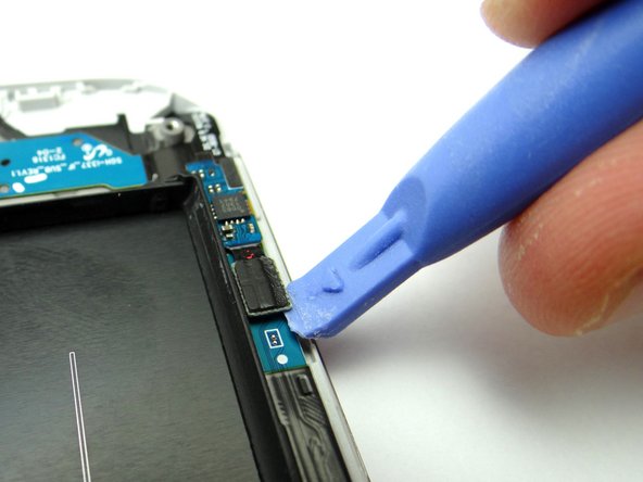 Picture 2: Use the Blue Pry Tool to disconnect the soft keys ribbon from the charging port ribbon.