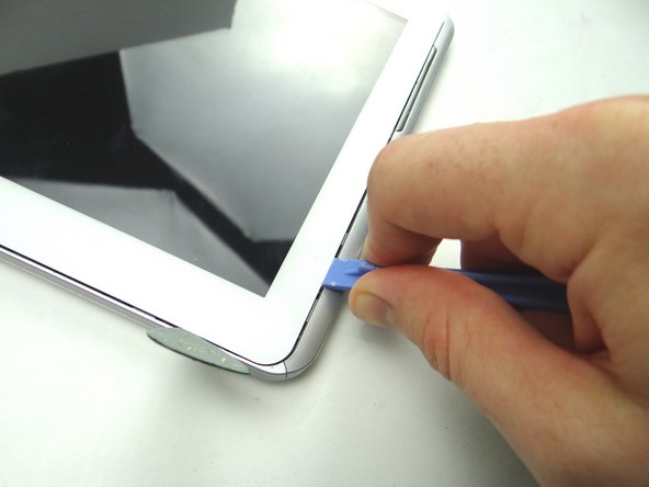 Picture 2:  Slowly work your way up with the blue pry tool, pivoting the front panel slightly up from the rear case.