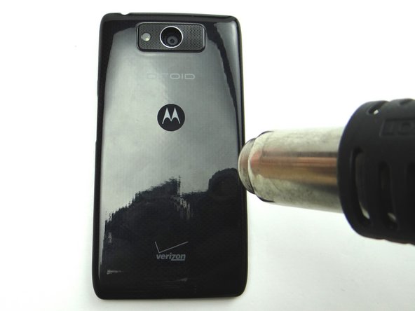 Picture 1: Apply 100° Celsius heat to the center of the back of the phone for 30 seconds to loosen adhesive holding the battery cover in place.