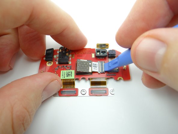 Use the blue pry tool to open the rear camera ZIF connector.