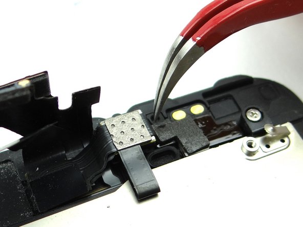 Squeeze curved-tip tweezers into closed position and place the tip in the center of the spacer.