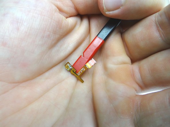 Use the flat end of the spudger to separate the cable from the frame.