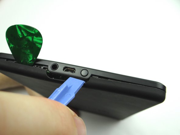 Picture 1: Slide the blue pry tool right, under the power button.