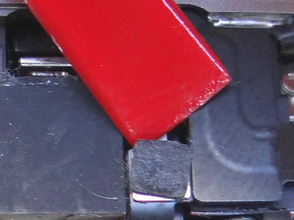 Wedge the flat end of the black spudger under the wi-fi antenna connecter and gently lift to release from logic board.