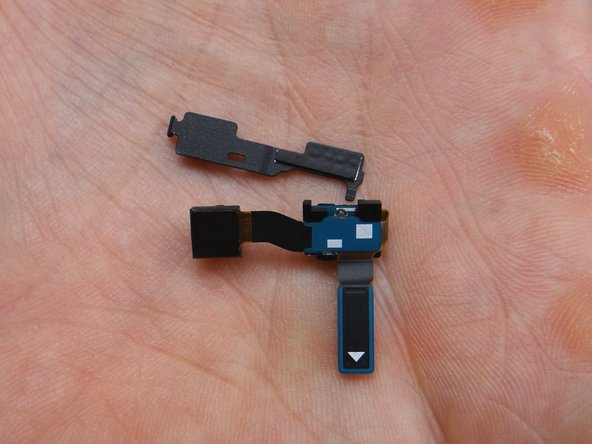 Gently peel up the proximity sensor on the right.  Once it's free, continue peeling right-to-left to free the front-facing camera.