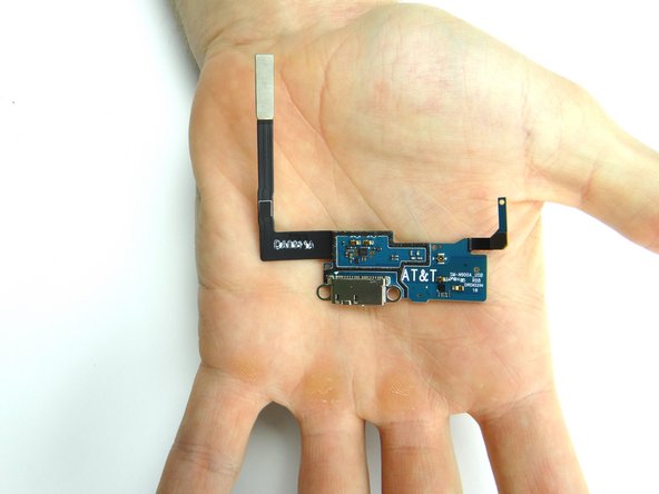 Finish peeling up the charging port with your fingers.  Then place the charging port face down (adhesive side up) in ZONE V.