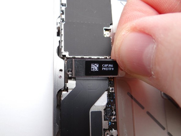 Picture 3: Lift the charging port assembly shield with your fingers (or tweezers, if necessary) and place with screw in SLOT 11.