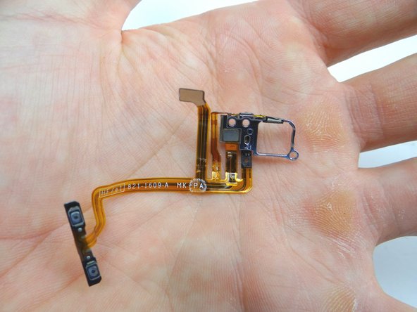 Use the metal spudger to separate the volume button bracket from the volume button cable.  Place both in COMPARTMENT D (with volume buttons).