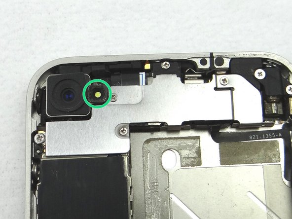 Use a pair of tweezers to remove the outer plastic ring (if present) located on top of the rear camera's flash. Place in COMPARTMENT B.