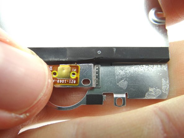 Press the backside of the contact pad into place on the underside of the metal plate.