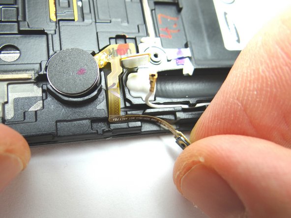 Continue peeling the ribbon cable away with your fingers to release it from the side of the front assembly.