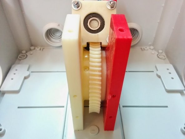 Slide the Axis Gear and Axis Gear Spacer in place inside the gear assembly of Altitude, making sure the Axis Gear is oriented in a side you can then screw the bolt that holds it to the Axis Tube.