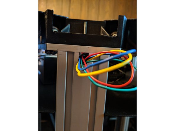 Looking where the wires exit the top of the tower, you will now feed the wires through to the inside of the top of the machine.  See Figure 1.