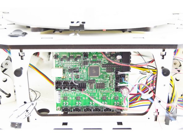 Install the RAMBo board back into the printer. Get the top tabs engaged into their slots, and once engaged, pivot the board pushing the bottom of the board into place.