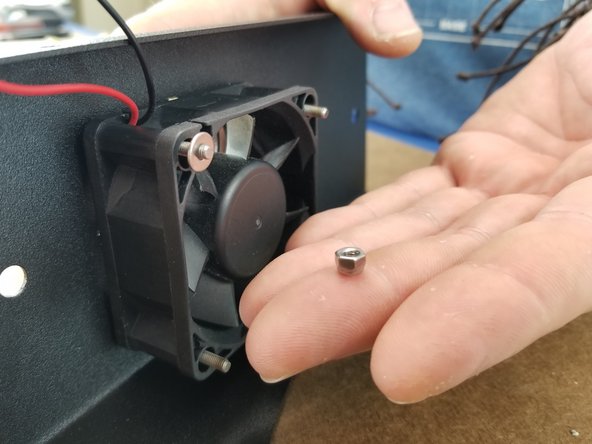 Insert the fan with the arrow facing the sheet metal over the 4 screws.