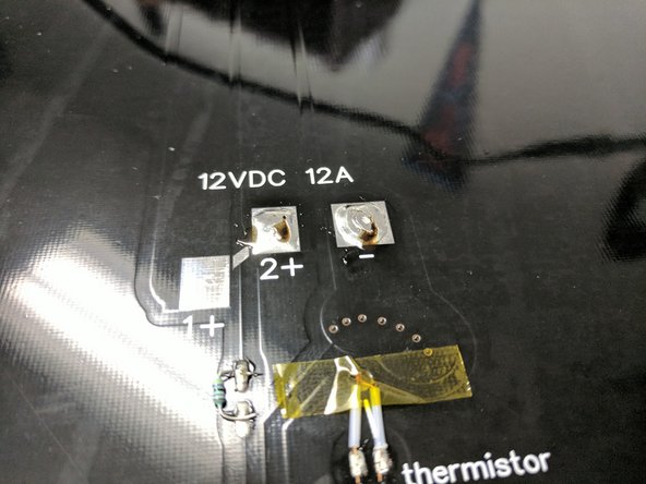 Move the heated bed close enough to the printer that the wires will reach the pads that you have tinned.