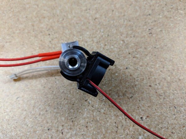 Insert the fan shroud over the  heat sink .  There is a tab on the fan shroud that inserts into the first large gap between the fins on the heat sink.  Press this tab fully into the heat sink.