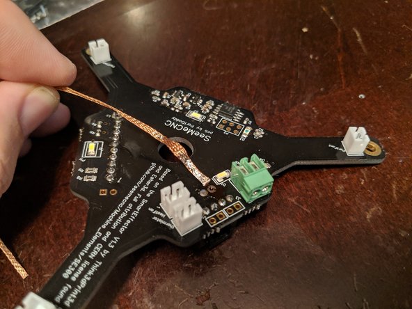 Place the soldering iron on the desoldering braid and allow it to heat up both the desoldiering braid and solder point and the desoldering braid will wick up the solder.