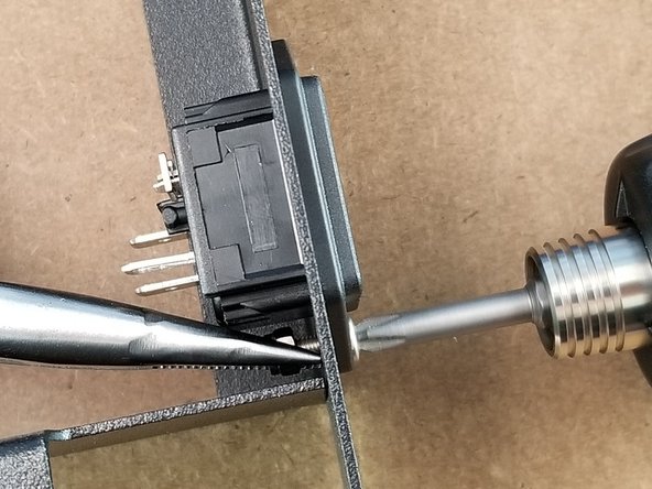Holding the M3 lock nuts with a pair or pliers, screw the plug reciever in place to the power supply bracket securing it in place.