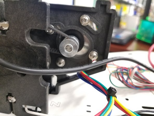 To Tension the belts push the motor forward in the injection molded mount while feeling the belts. Once you have reached the desired tension. Tighten down the 3 screws that were left loose.