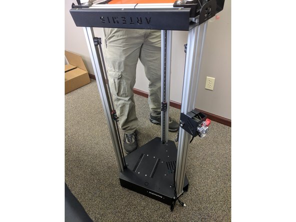 The base assembly is now ready to be installed. To do so we will need to carefully flip the machine over and set it on the floor. It is recommended to have something on the floor to protect it (carpet, cardboard, towel, etc) from getting scratches.