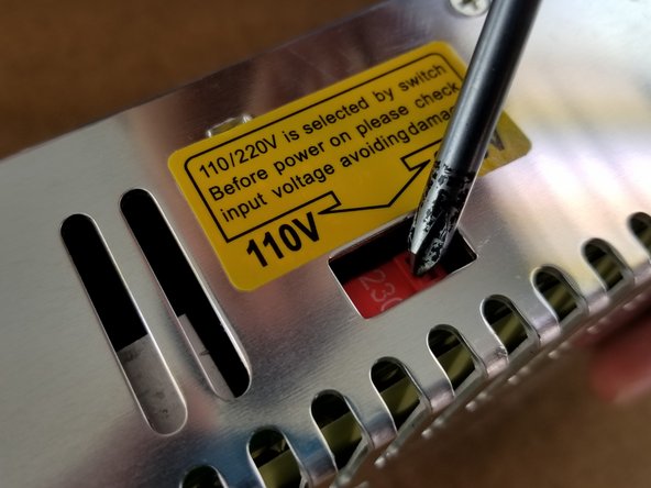 Locate the red voltage selector switch on the power supply.