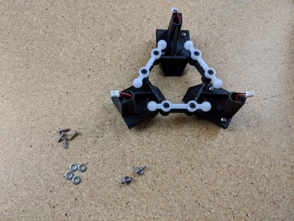 Press each ball arm over the mounting posts on the effector platform.