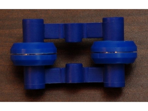 Press fit the outer spring arm on to the two small posts protruding from the inner spring arm.  The fit is very tight, but they will fit!