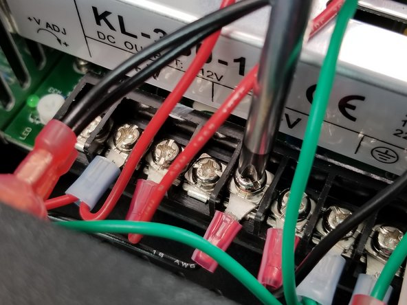 Feed the ring terminal into the power supply bracket through the hole in the front as shown in Pic 1.