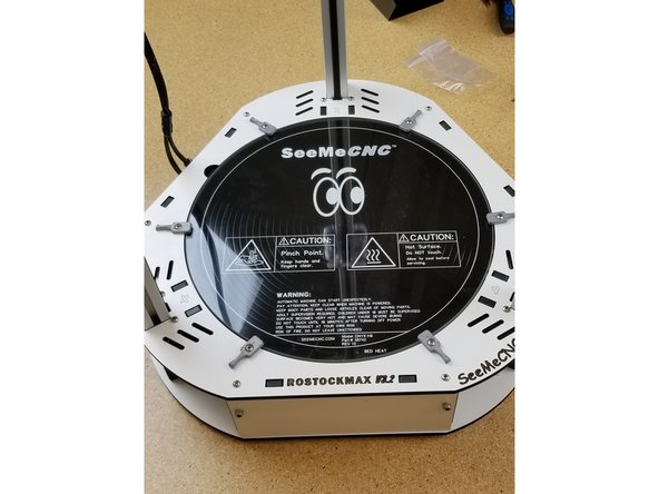 Install the bed as shown, and spin the bed clamps as shown to securely hold the glass in place.