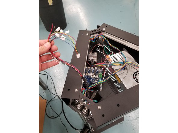 Coming from the X tower, a short section of mesh loom houses the hotend whip wires and the extruder wires. Disconnect all connectors on wires exiting this mesh loom.