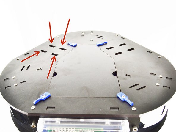 Position the spool holder on the top plate of the machine in the four rectangular cutouts.