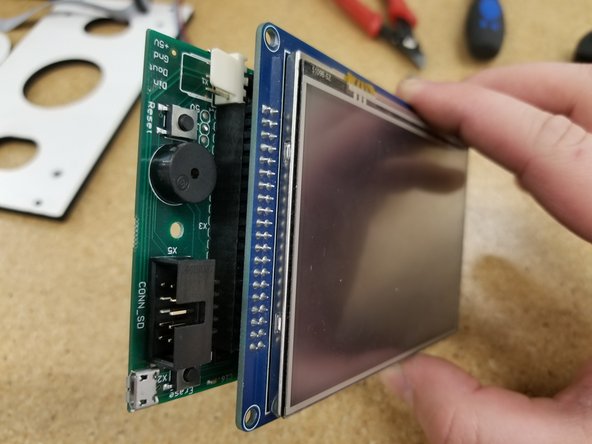 Plug in the two cables as pictured. Make sure the green wire on the molex connector is oriented towards the ribbon cable, and the red wire on the ribbon cable is oriented towards the  "Erase" button.