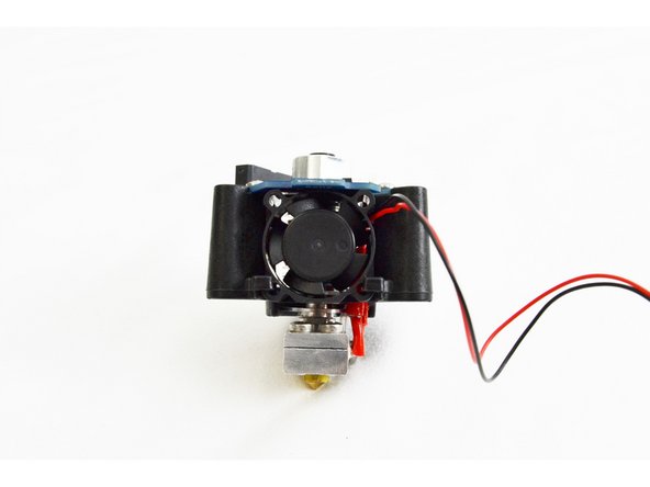 Run the 25mm fan wire up and through the notch in the PCB, wrap it around the PTC adapter in the center of the hot end and then plug it into the HE header on the PCB.