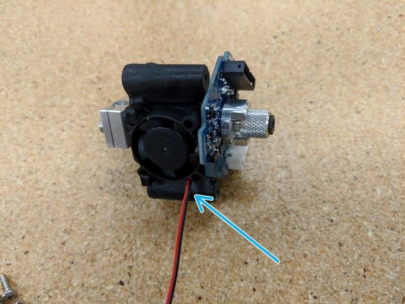 Install the cooling fan into the retaining clips, under the HE280 PCB.  The fan blades should face away from the hot end, as shown.