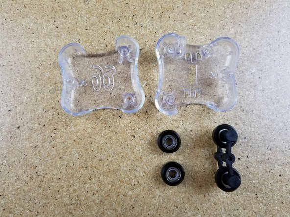 Install two R4 bearing and a spring arm assembly on to an inner carriage half. Make sure you match the spring arm orientation as shown - installing it backwards can damage the spring arms!