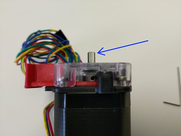 Press the red release lever and slide the hobbed drive roller down into the EZR Struder assembly until the midpoint of the hobbed portion is aligned with the split between the base and cover pieces (indicated by a green arrow)