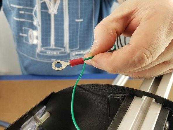 On the stripped end of the green wire, place the large ring terminal over the wire and crimp it into place securely.