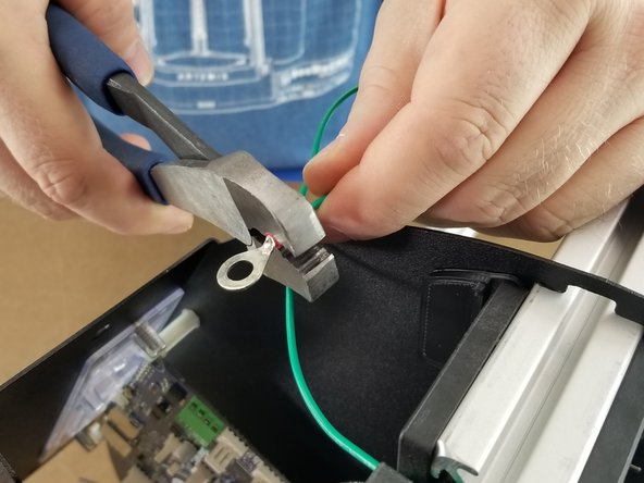 On the stripped end of the green wire, place the large ring terminal over the wire and crimp it into place securely.