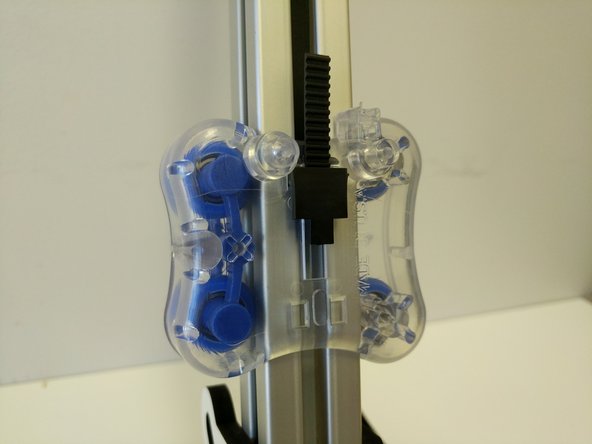 Lift up on the belt (less than 1&quot; above the top of the carriage) and insert the belt clips legs into the two upper rectangular cutouts.