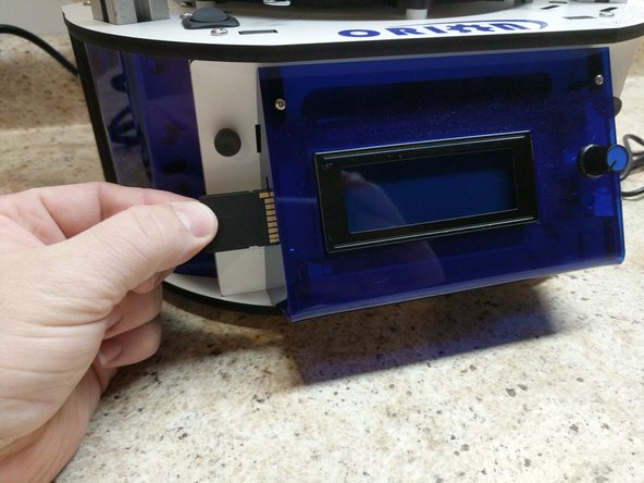 Insert the SD card into  the side of the LCD assembly. Note the orientation of the SD card, the metal contact should be facing you.