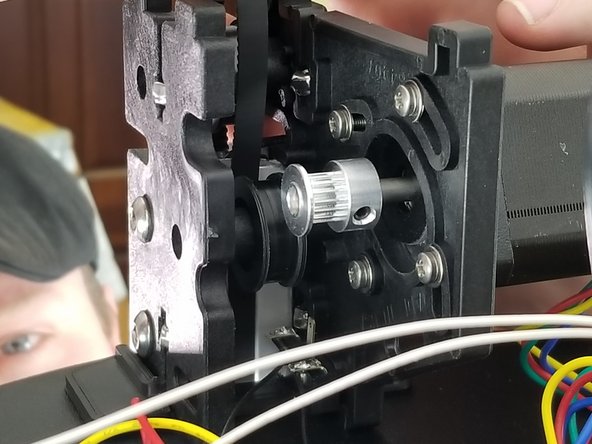 Looking at Pic 1, you will route the belt down the extrusion, over the top idler, but behind the lower idler. This will feed the belt down below the upper frame.