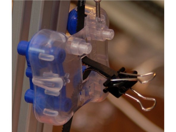 Install two RZ44 rollers and a spring arm on to an inner carriage half.  Make sure you match the spring arm orientation as shown - installing it backwards can damage the spring arms!