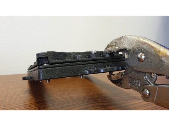 Using a pair of vise-grip pliers, c-clamp, or an extra set of hands, apply pressure near the middle of one of the short edges of the assembly (be sure not to cover up the counter-bore for the 6-32 x 5/8&quot; Socket Head Cap Screw)