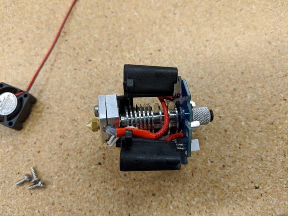 Insert the hot end assembly into the HE280 PCB Mount so that the tab with &quot;SeeMeCNC&quot; on it is aligned with the cooling fan retaining clips (identified by the red arrows).