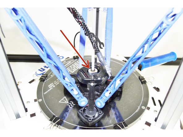 Insert the Bowden (PTFE) Tube into the top of the hot end. Press the tube down until you feel it seat in the bottom of the hot end. Press the hot end effector down so the nozzle is against the glass plate and give the Bowden (PTFE) Tube one more good push to ensure that it is seated fully.