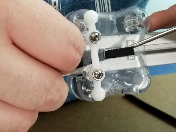 From the belt hanging from the top of the machine, feed the belt behind the carriage top and use a flathead screwdriver or other tool to help feed the belt out the hole in the center of the carriage as shown in Pic 2 and 3.