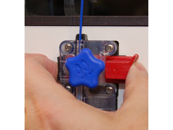 Squeeze the plunger in to feed the new filament into the extruder.  Feed it all the way through and in to the hot end.