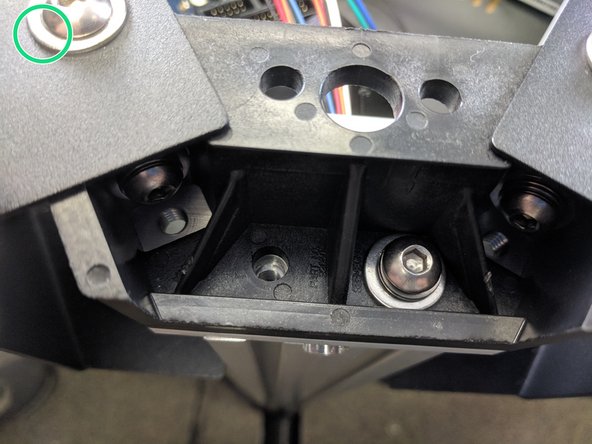 Attach the tower to the upper assembly using 2 each of the provided 1/4-20 x 1" long button head screws, split ring washer, and flat washer, stacked as shown in the image with the blue circle. Fully Tighten.